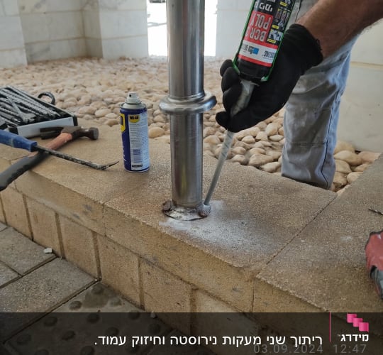 אדם מתקין עמוד מתכת עם חומר איטום על קיר לבנים